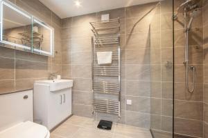 a bathroom with a shower and a toilet and a sink at Premium 2 Bed Apt 1st floor sleeps 4 adults in Oban town in Oban +40 photos