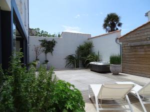 a patio with two chairs and a bath tub at Maison Le Clos Neraud avec piscine et SPA in Saint-Martin-de-Ré