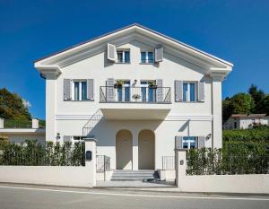 een wit huis met een balkon bij Villa Gremì - Monforte d'Alba in Monforte dʼAlba