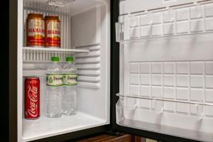 an open refrigerator with bottles of water and soda at PING DIAMOND HOTEL in Hanoi