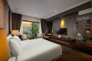 sypialnia z dużym białym łóżkiem i telewizorem w obiekcie PING DIAMOND HOTEL w mieście Hanoi