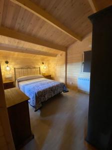 1 dormitorio con 1 cama en una habitación de madera en El naval de la Parra II en Sejas de Sanabria