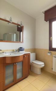 a bathroom with a toilet and a sink and a mirror at VACACIONES VILLASANA in Villasana de Mena