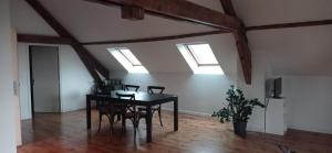 ein Esszimmer mit einem Tisch, Stühlen und Oberlichtern in der Unterkunft Appartement moderne et lumineux in Brive-la-Gaillarde