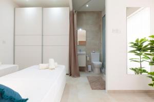 a bedroom with a white bed and a bathroom at FL56 - New 3storey House - private entrance & roof in Il-Furjana +30 photos
