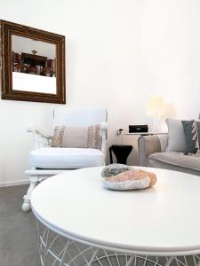 a white living room with a white table and chairs at Pino di Loto Boutique Bed & Breakfast in Kini