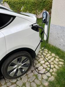 un'auto è collegata a un caricabatterie per auto elettriche di ESSENCE - Charming Suites a Riva del Garda