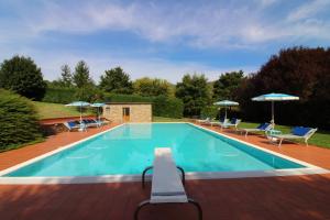 a swimming pool with chairs and umbrellas at Casale Lorenzo in Subbiano
