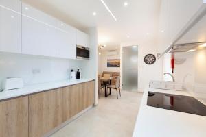 une cuisine avec comptoirs blancs et une salle à manger dans l'établissement FL56 - New 3storey House - private entrance & roof, à Il-Furjana