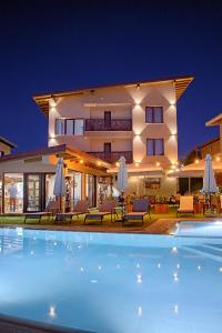 Villa con piscina por la noche en Guest house Wishmore, en Banya