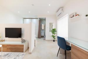 een woonkamer met een bureau en een televisie bij FL56 - New 3storey House - private entrance & roof in Il-Furjana