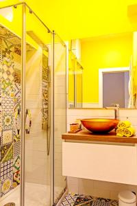 a yellow bathroom with a sink and a shower at Bella Vista House-Sorrento coast - free parking-solarium in Vico Equense