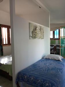 a bedroom with a bed and a painting on the wall at LA CABAÑA DE HUERTAMAR in Zorritos