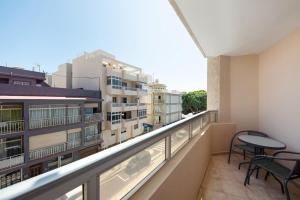 - un balcon avec une table, des chaises et des bâtiments dans l'établissement Durazno Sur 205, à El Médano