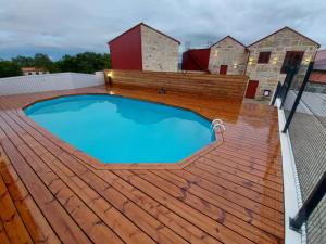 a large swimming pool on a deck with a fence at Casa de Penedones - Ventos de Barroso in Penedones