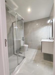 a bathroom with a shower and a sink and a toilet at Casa de Penedones - Ventos de Barroso in Penedones