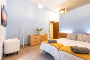 1 dormitorio con 1 cama blanca grande y vestidor en La Bakery De Vegueta en Las Palmas de Gran Canaria