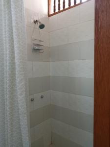 a bathroom with a shower with a shower curtain at LA CABAÑA DE HUERTAMAR in Zorritos