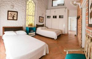 a bedroom with two beds and a window at Hotel Kalma in Santa Fe de Antioquia