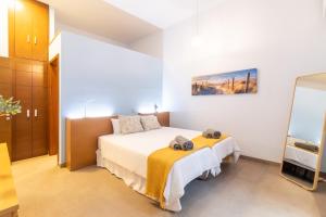 Un dormitorio con una cama con una manta amarilla. en La Bakery De Vegueta en Las Palmas de Gran Canaria