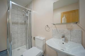 y baño con aseo, ducha y lavamanos. en Alpha Lofts, Huddersfield, en Huddersfield