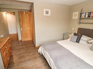 1 dormitorio con 1 cama grande y suelo de madera en Bell Cottage, en Holmfirth