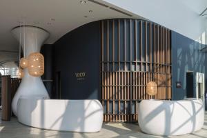 voco Milan-Fiere, an IHG Hotel في ميلانو: متجر به طاولتين بيضاء أمام مبنى