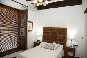a bedroom with a white bed and two night stands at HABITACIONES LAS TERMAS in Guadix