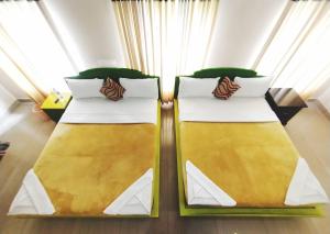 duas camas num quarto com amarelo e branco em Dreamnest Residency em Kalpatta mais 21 fotografias