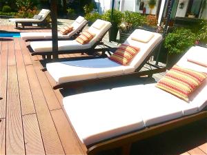 a row of white beds sitting on a patio at Casa Relogio de Sol in Lamego