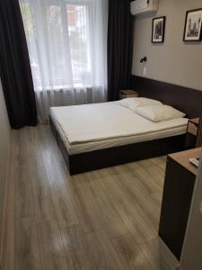 1 dormitorio con 1 cama y suelo de madera en Hotel Relax, en Kirov