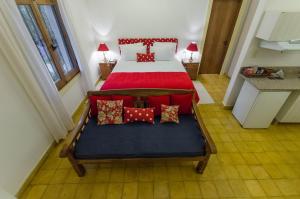 1 dormitorio con 1 cama con sábanas y almohadas rojas en La Casona Hotel Boutique, en Asunción