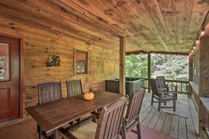 a wooden dining room with a table and chairs on a porch at Blue Ridge Cabin Hot Tub, Fire Pit and Grill! in Blue Ridge