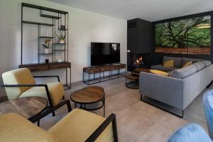 sala de estar con sofá y TV en BEUKENHOUSE, en Drogenbos