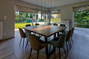 uma sala de jantar com uma mesa de madeira e cadeiras em BEUKENHOUSE em Drogenbos