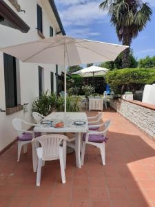 un tavolo e sedie con ombrellone su un patio di Casale Gelsomino a Rovolon