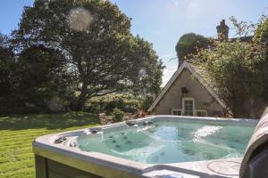 a hot tub in a yard next to a house at Home Farm House in Crowborough