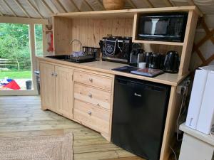 a kitchen with a stove and a microwave at Yurt with Hot Tub near Hartington, Peak District in Buxton