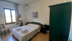 1 dormitorio con 1 cama con toallas en Casa Maria Orosei-Cala Liberotto, en Cala Liberotto