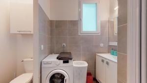 een kleine badkamer met een wasmachine bij L' Appart' des Achards - YUZU in La Mothe-Achard