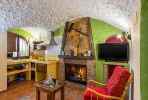 sala de estar con chimenea y TV en Cazorla Casas Cueva, en Hinojares