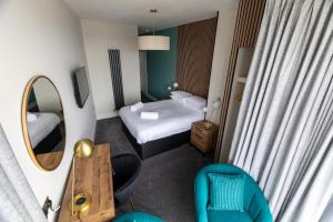 a small hotel room with a bed and a mirror at Ty Belgrave in Aberystwyth