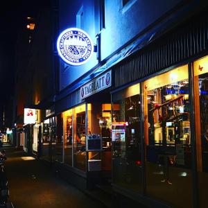 un restaurant avec un panneau sur son côté la nuit dans l'établissement TAGBLATT Apartment 2, à Tuttlingen