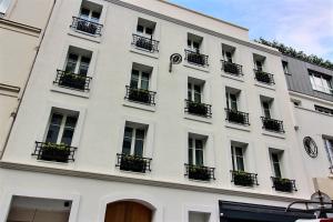 a white building with balconies and a clock on it at 218931 - Appartement 4 personnes à Paris in Paris