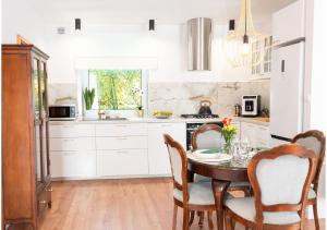 a kitchen with white cabinets and a table and chairs at Apartament Mała Wenecja in Barczewo