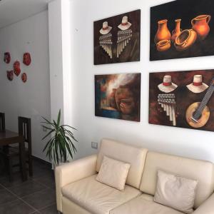 una sala de estar con sofá y algunas fotos en la pared en Guest House Salta en Salta