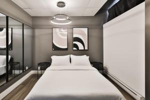 1 dormitorio con 1 cama y 2 cuadros en la pared en Hygie Boutique Hotel, en Montreal
