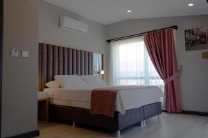 Un pat sau paturi într-o cameră la L'opera Deluxe Hotel