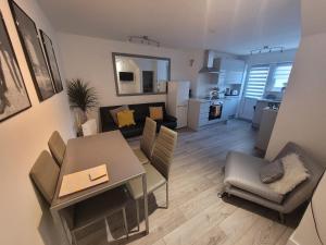 uma sala de estar com uma mesa de jantar e uma cozinha em Entire apartment with sun filled private garden em Margate