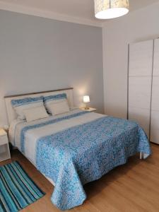 a bedroom with a large bed with a blue blanket at Beja Garden in Beja